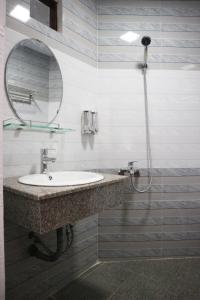 a bathroom with a sink and a shower with a mirror at Anh Quân Hotel in Quy Nhon