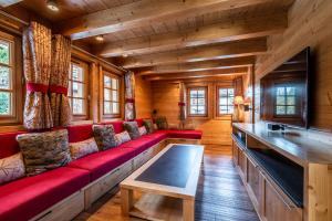 a red couch in a room with wooden walls at Abachi Chalet Les Gets - by EMERALD STAY in Les Gets