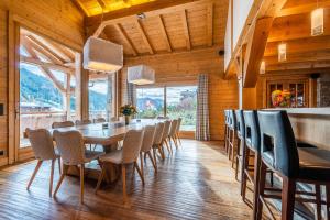 a long dining room with a long table and chairs at Abachi Chalet Les Gets - by EMERALD STAY in Les Gets