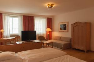 Hotel Seethaler في شتراوبينج: غرفة نوم مع سرير وغرفة معيشة