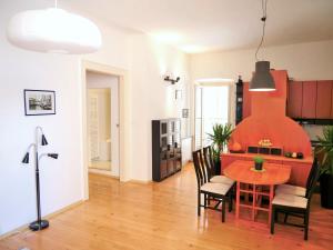 une cuisine et une salle à manger avec une table et des chaises rouges dans l'établissement 3PAPIGE Apartment, à Piran