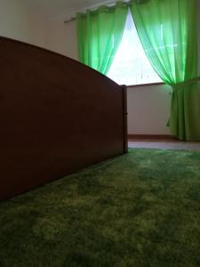 a room with green curtains and a large window at Casa Serra da Lapa in Viseu