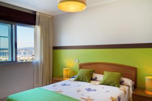 - une chambre dotée d'un lit avec un mur vert dans l'établissement Duerming Portonovo Picó, à Portonovo