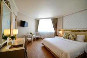 Habitación de hotel con cama grande y escritorio. en Wangcome Hotel en Chiang Rai