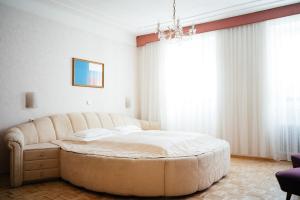 a large bed in a bedroom with a large window at Hotel Am Brillantengrund in Vienna