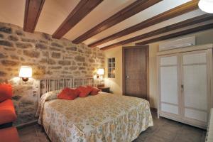 a bedroom with a bed and a stone wall at Apartamentos Santa Agueda in Valderrobres