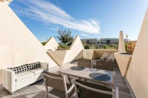 balcone con divano, tavolo e sedie di Cap d'Agde Naturiste a Cap d'Agde