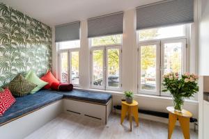 a living room with windows and a blue bench at Prinsengracht Canal Studios in Amsterdam