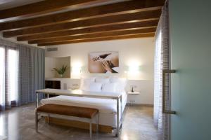 パルマ・デ・マヨルカにあるPetit Palace Hotel Tresの白いベッドと木製の天井が備わるベッドルーム1室が備わります。
