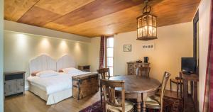 a bedroom with a bed and a table and a television at Auberge Du Relais Postal in Asselborn