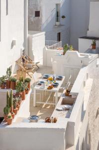 a terrace with white tables and potted plants at Calumàre in Polignano a Mare