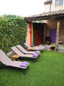 una fila de tumbonas en el césped en un patio trasero en La Casona de Castilnovo - Gay Men Only, en Valdesaz