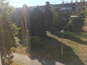 a park with trees and a building in the background at Lovely Apartment 2 in Belgrade