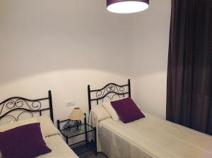 a bedroom with two beds and a lamp at Alzahira 1 in Córdoba
