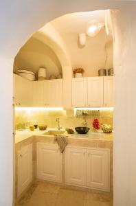 a kitchen with white cabinets and a sink at Calumàre in Polignano a Mare