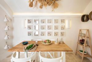 a dining room with a wooden table and white chairs at Calumàre in Polignano a Mare