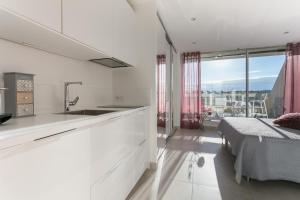 uma cozinha branca com um lavatório e uma cama num quarto em Cap d'Agde Naturiste em Cap d'Agde