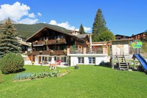 una casa grande con un patio con parque infantil en Guggerzyt, en Grindelwald