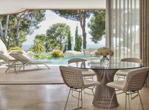 a dining room with a glass table and chairs at Grand-Hôtel du Cap-Ferrat, A Four Seasons Hotel in Saint-Jean-Cap-Ferrat