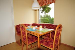 una mesa de comedor y sillas con copas de vino. en Apartment " LELLGEN " en Wilwerwiltz