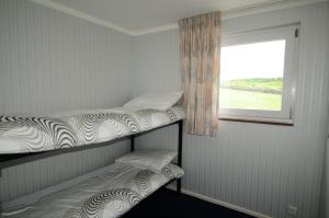 2 łóżka piętrowe w pokoju z oknem w obiekcie Apartment " LELLGEN " w mieście Wilwerwiltz