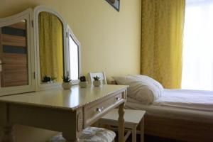 1 dormitorio con cama, tocador y espejo en Hostel DV Morski - z prywatnymi łazienkami, en Gdynia