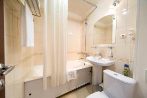 a bathroom with a sink and a toilet and a mirror at Tatarstan Business-Hotel in Naberezhnyye Chelny