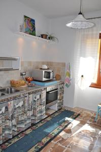 La cuisine est équipée d'un évier et d'un four micro-ondes. dans l'établissement Pà Blanc B&B, à Alghero