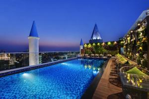 una piscina en la azotea de un edificio por la noche en The Fern Residency Jaipur en Jaipur