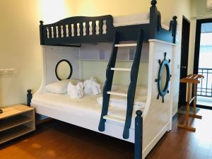 a bedroom with a bunk bed with white sheets at Baan Sang Singh in Chiang Mai