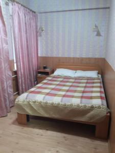 1 dormitorio con 1 cama con edredón a rayas en Milar Hotel, en San Petersburgo