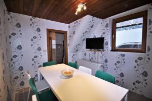 ein Esszimmer mit einem weißen Tisch und grünen Stühlen in der Unterkunft Monteurhaus Burgberg - Giengen an der Brenz in Burgberg