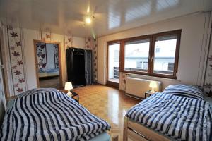 a bedroom with two beds and a large window at Monteurhaus Burgberg - Giengen an der Brenz in Burgberg