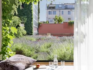 een raam met uitzicht op een tuin bij Boutiquehotel Stadthalle in Wenen