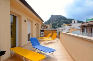 un balcón con sillas amarillas y azules en un edificio en PORT 23 ATIC en L'Estartit