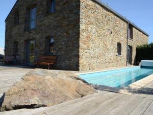 una gran roca junto a un edificio con piscina en Gorgeous holiday home in Stoumont with garden, en Stoumont