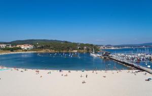 a group of people on a beach near a marina at Duerming Bolera Pico in Portonovo