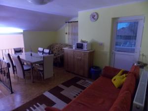 ein Wohnzimmer mit einem Sofa und einem Esstisch in der Unterkunft Casa Floro in Comăneşti