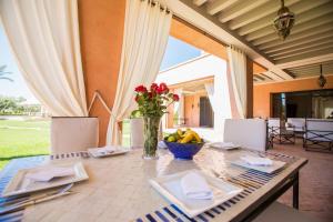 a table with a vase of flowers and a bowl of fruit at Villa Koutoubia, jardin luxuriant, piscine et spa in Marrakech