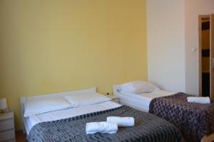 Dos camas en una habitación con toallas. en Hostel DV Morski - z prywatnymi łazienkami, en Gdynia