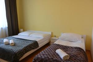 two beds sitting next to each other in a bedroom at Hostel DV Morski - z prywatnymi łazienkami in Gdynia