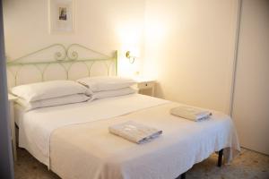 a bedroom with a white bed with two towels on it at Hotel Europa in Ischia