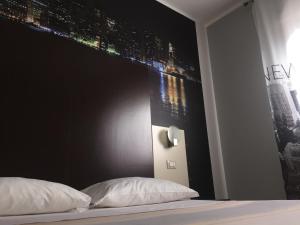 a bedroom with a black headboard and a bed with white pillows at Hotel Opera' in Moscufo