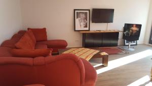 a living room with a red couch and a tv at Ferienhaus Boedefelder in Winterberg