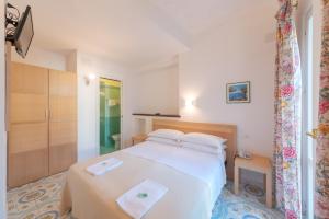 a bedroom with a white bed with towels on it at Hotel Europa in Ischia
