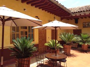 帕茨誇羅的住宿－波薩達德拉薩魯德酒店，一个带桌椅和遮阳伞的庭院