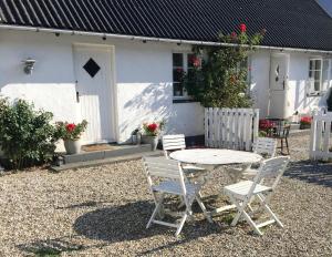 a table and chairs in front of a white house at Ebogaard in Hillerød