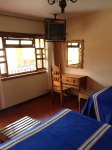 1 dormitorio con 1 cama, escritorio y ventanas en Posada de la Salud, en Pátzcuaro