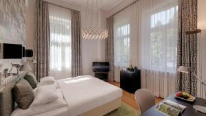 a bedroom with a large bed and a large window at Boutiquehotel Dreesen - Villa Godesberg in Bonn
