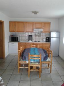 a kitchen with a table and chairs and a refrigerator at Gite les Myosotis in Saint-Jean-Saint-Nicolas